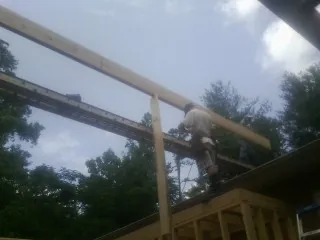Carpenter setting a ridge beam over a new addition frame — Ice Dam Removal by Roofing Brothers in Gordo
