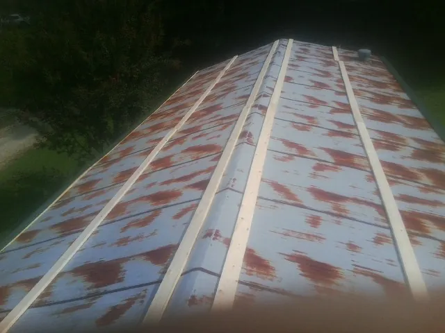 Rusted metal roof panels with new wood purlins before replacement — Storm Damage Roof Repair in Gordo by Roofing Brothers
