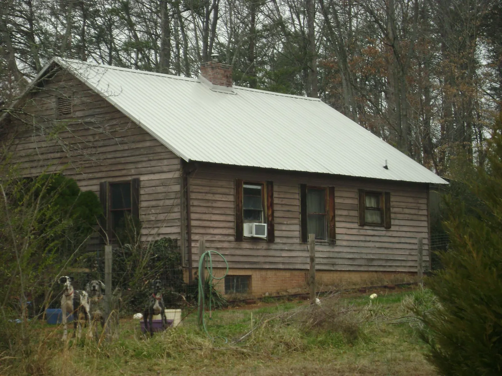 White metal roof on an old wood sided farmhouse, from a Metal Roof Installation job in Gordo